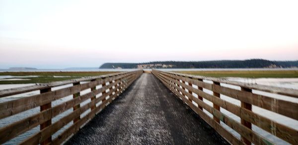 Empty road along landscape against clear sky