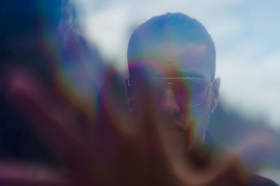 Close-up portrait of young man against mountains and sky