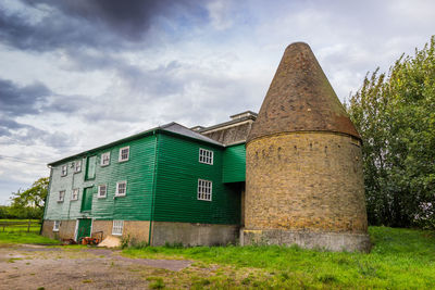 View of old building on field against cloudy sky