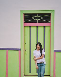 Woman standing against green door