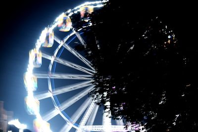 Low angle view of illuminated ferris wheel against sky at night