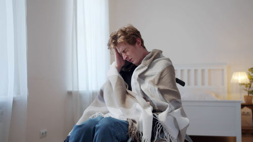 Side view of young woman sitting at home