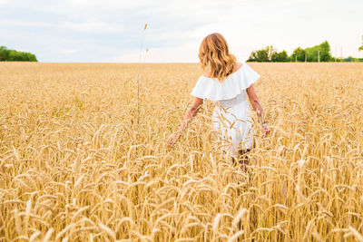 Woman standing on field against sky