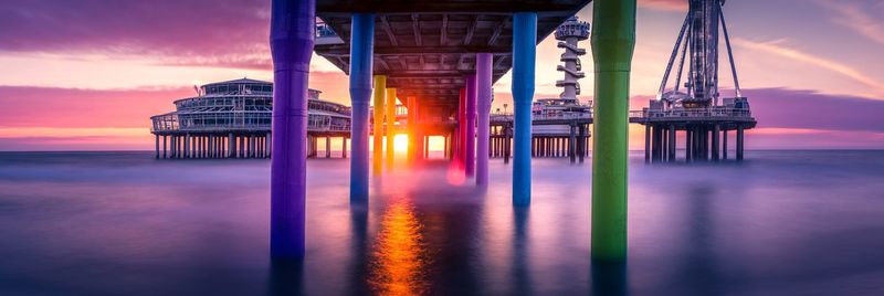 Pier on sea against sky during sunset