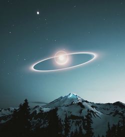 Low angle view of snowcapped mountain against sky at night