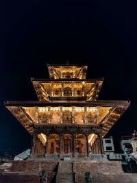 Low angle view of illuminated building against sky at night