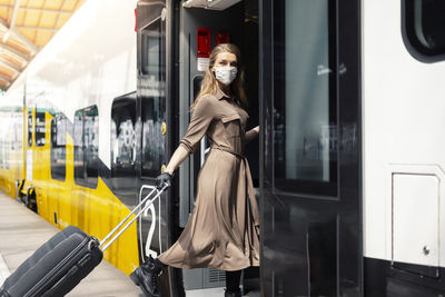 Portrait of woman wearing mask entering in train