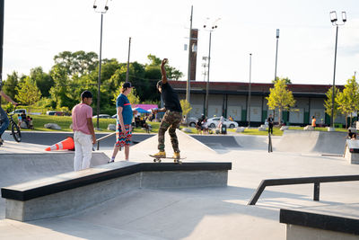 People on skateboard in city against sky