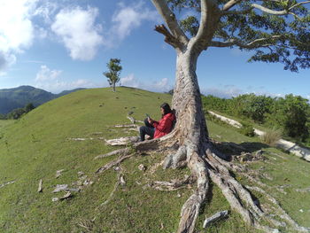 People sitting on grass against sky