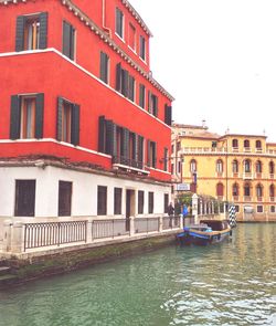 Boats in canal along buildings