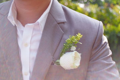 Midsection of woman holding white flowering plant