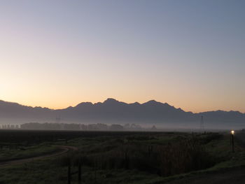 Scenic view of field against clear sky during sunset