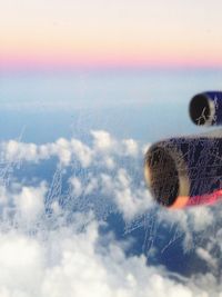 Close-up of airplane flying in sky during winter