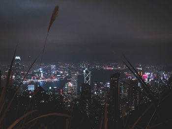 Illuminated buildings in city against sky at night