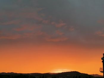 Scenic view of dramatic sky over silhouette landscape