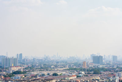 Aerial view of buildings in city against sky