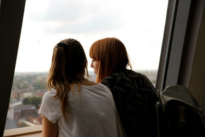 Rear view of woman looking through window