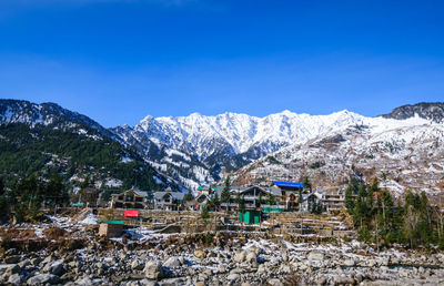 Scenic view of snowcapped mountains against blue sky