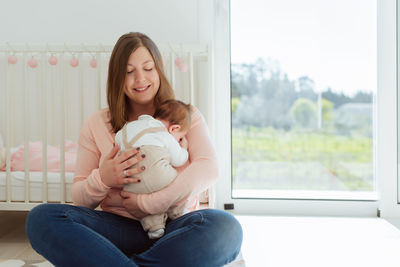 Mother carrying daughter at home