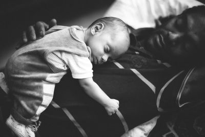 High angle view of baby boy sleeping on father