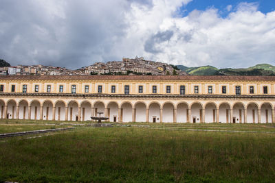 Panoramic shot of building on field against sky