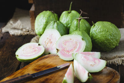 Guavas with cutting board on table