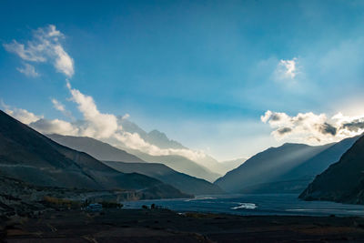 Scenic view of sea and mountains against blue sky