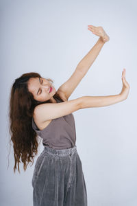 Portrait of smiling young woman against white background