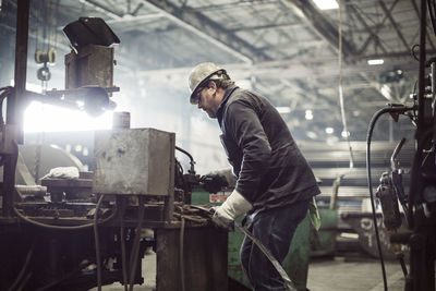 Worker operating machinery in factory