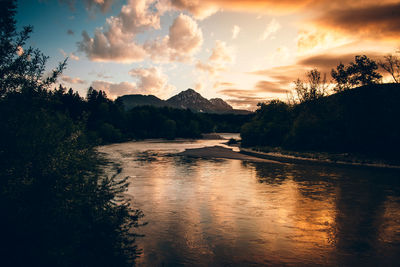 Scenic view of river against sky at sunset