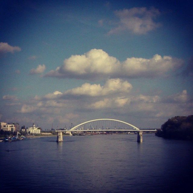 connection, bridge - man made structure, architecture, water, built structure, transportation, waterfront, bridge, river, engineering, sky, suspension bridge, sea, cloud - sky, travel destinations, rippled, cloud, arch bridge, city, travel