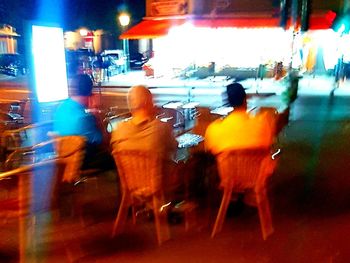 Rear view of man standing on city street at night