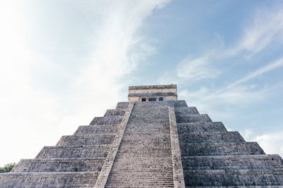 Maya ruins chichen itza against the blue sky with clouds.