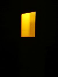 Close-up of yellow lamp against black background