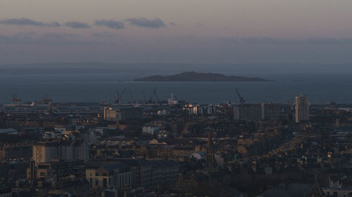 High angle view of townscape by sea against sky