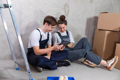 Side view of young man using digital tablet while sitting at home