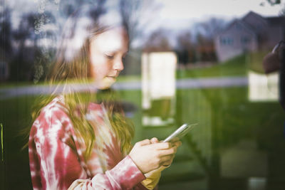 Midsection of woman holding mobile phone