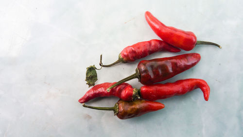 Close-up of red chili peppers against white background