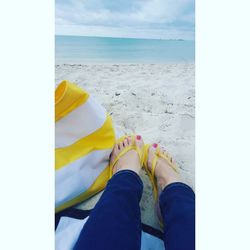 Low section of man standing on beach