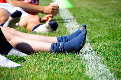 Low section of athletes wearing socks while sitting on field