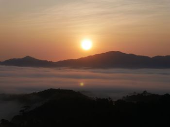 Scenic view of silhouette mountains against romantic sky at sunset