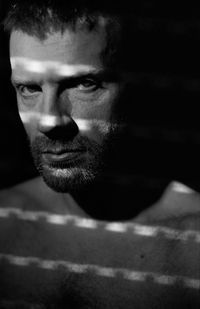 Close-up portrait of serious mature man in darkroom