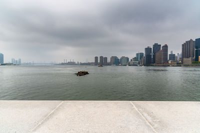 Scenic view of sea by buildings against sky