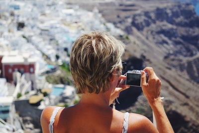 Rear view of woman photographing mountain