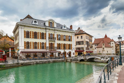 View of swimming pool by buildings against cloudy sky