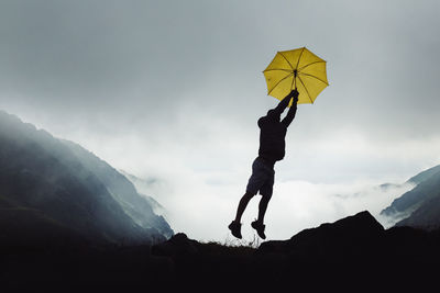 Low angle view of man holding umbrella