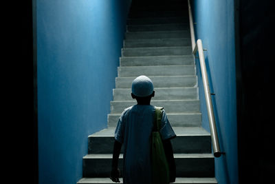 Rear view of boy standing on staircase