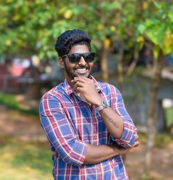 Portrait of young man wearing sunglasses standing outdoors