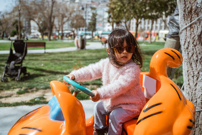 Side view of young woman sitting in park