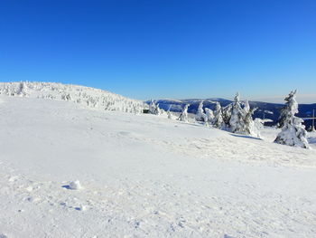 Scenic view of snowcapped mountains against clear blue sky